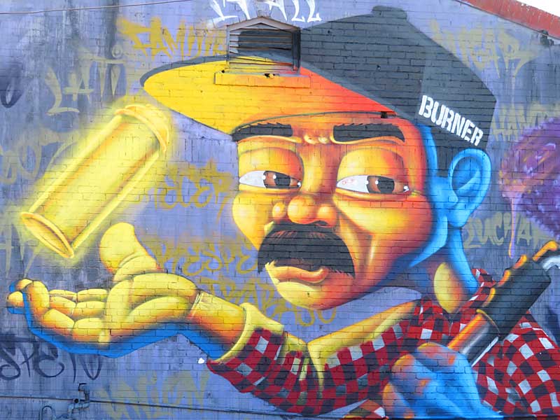 The ‘BURNER’ mural covers the northern end of this long building at The Paint Yard on Hoefgen Street near downtown San Antonio south of the Alamodome.